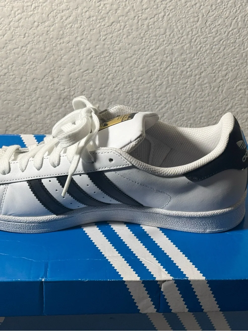 Adidas Superstar Sneakers with Black Stripes and Gold Tongue Logo
